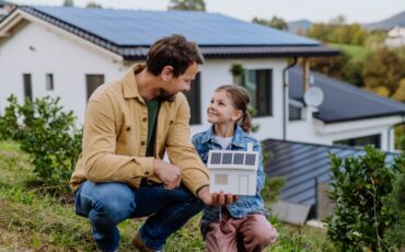 Little,Girl,With,Her,Dad,Holding,Paper,Model,Of,House